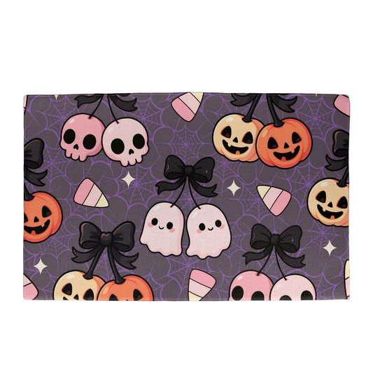 Spooky cute Halloween doormat with pumpkins, ghosts, skulls, candy corn, and spiderweb design on purple background
